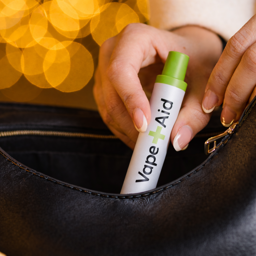 Hand grabbing a Vape+Aid diffuser from her purse