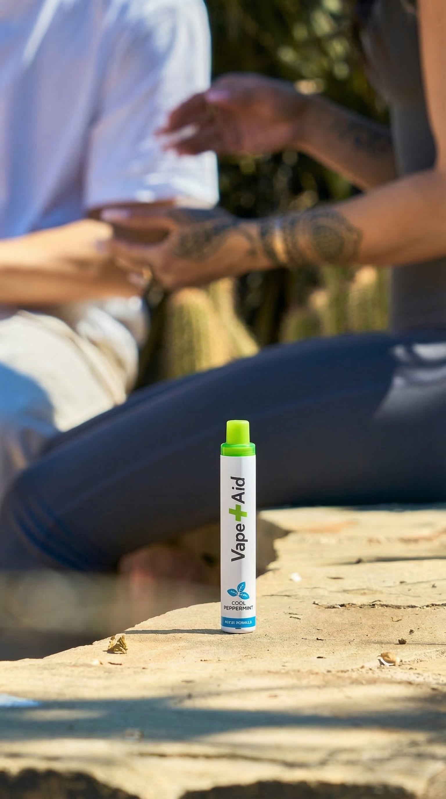 Vape+Aid product on a stone surface with people in the background