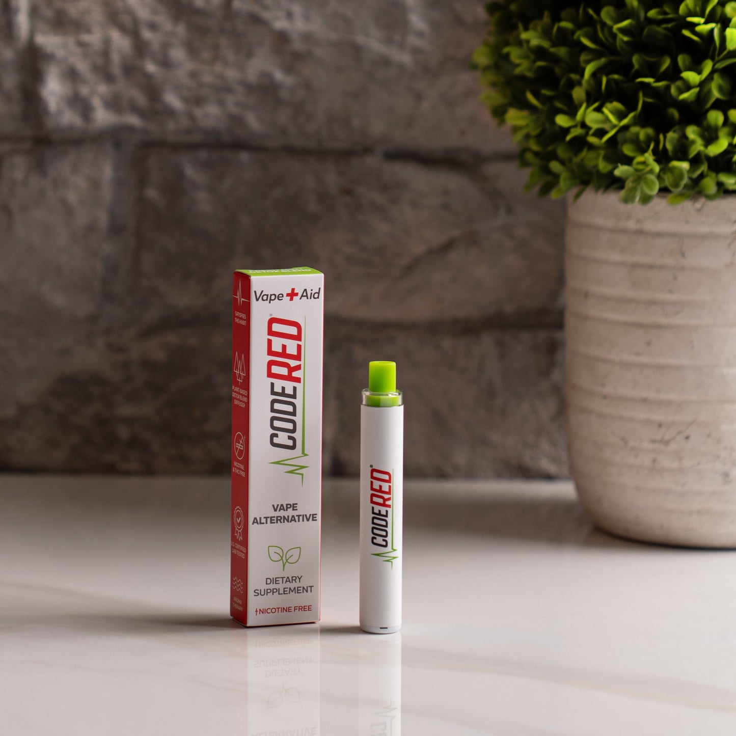 Code Red Vape+Aid and packaging on a surface with a plant in the background