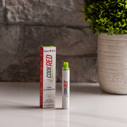 Code Red Vape+Aid and packaging on a surface with a plant in the background
