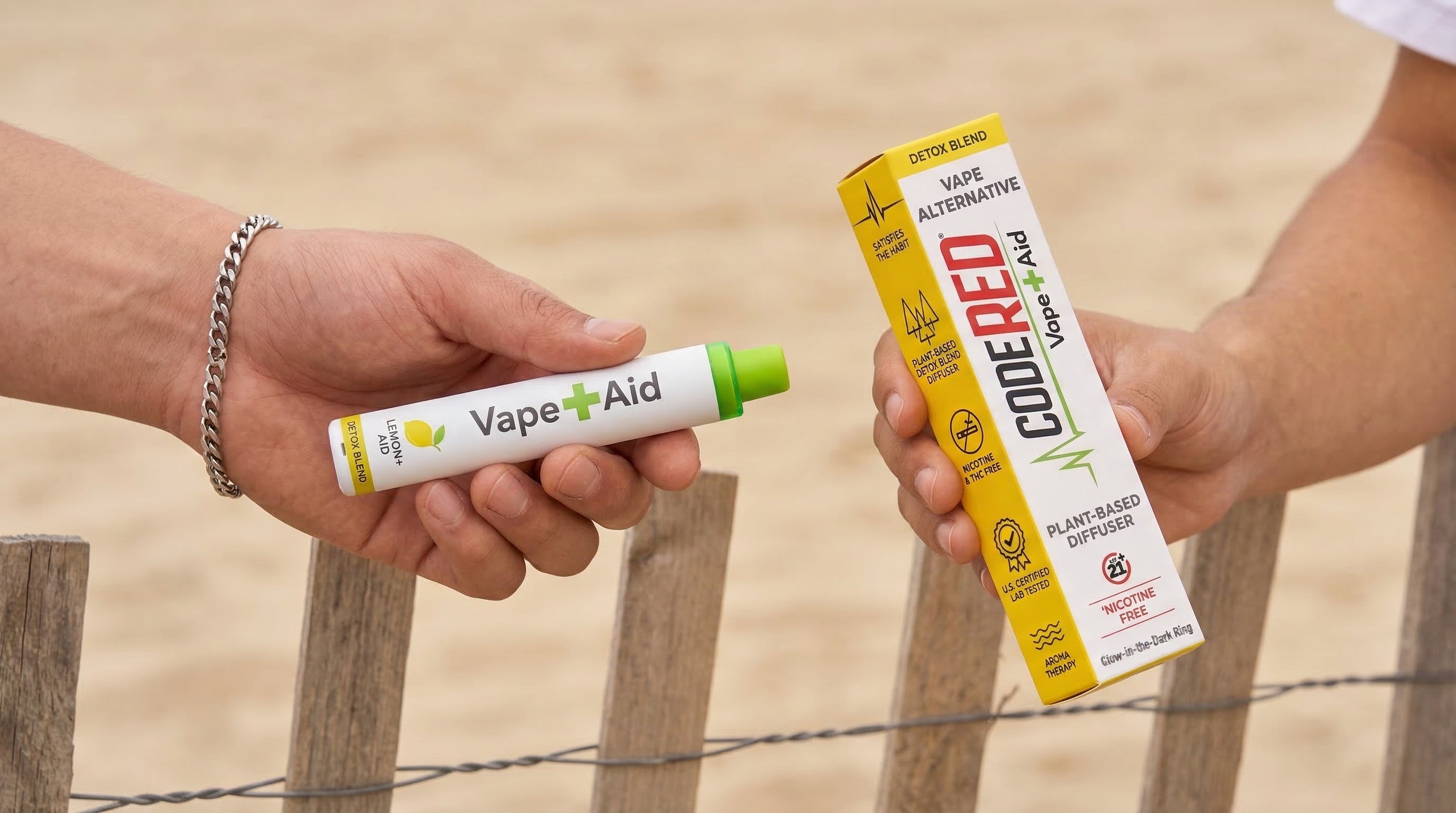 Two hands holding Vape+Aid diffuser and packaging against a wooden fence background.